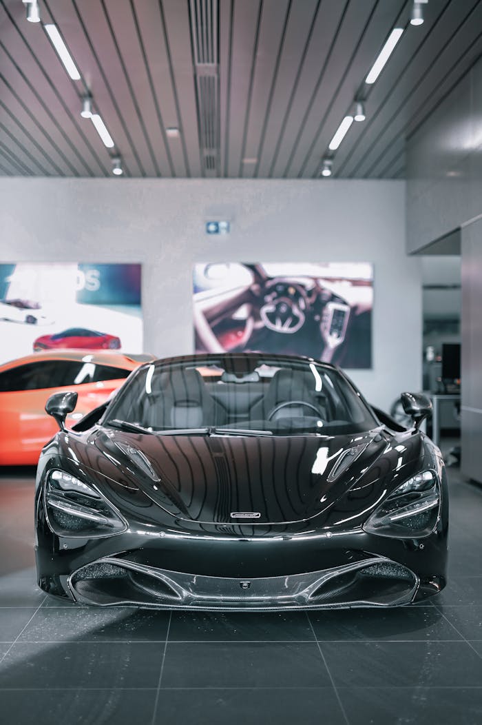 Services High-end black sports car showcased in a modern indoor showroom setting with ambient lighting.