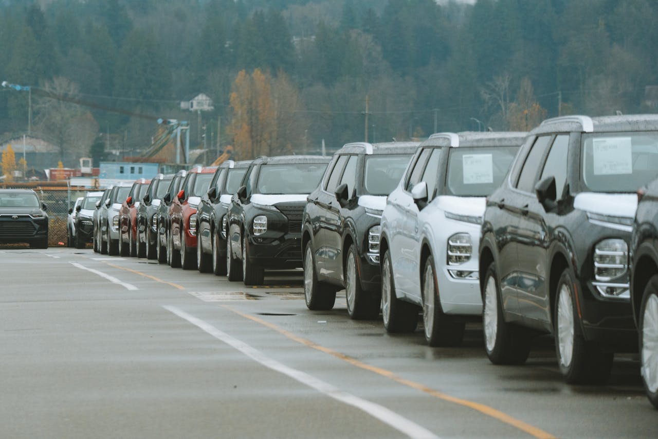 Services A line of new SUVs parked in an outdoor dealership lot, ready for sale.